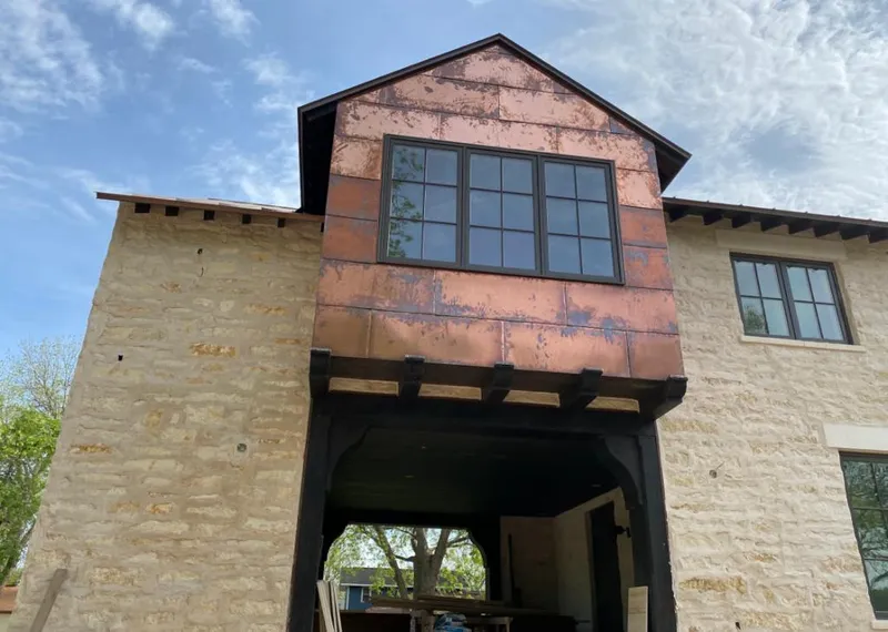 Copper metal panel facade on a stone building for Roof Repair in Valley City